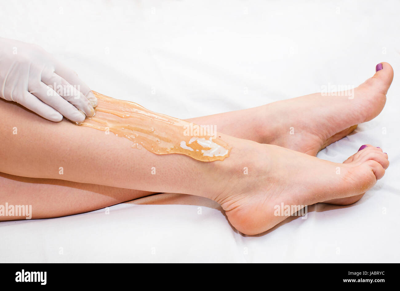 Epilazione processi zucchero donna passa in un salone di bellezza Foto Stock