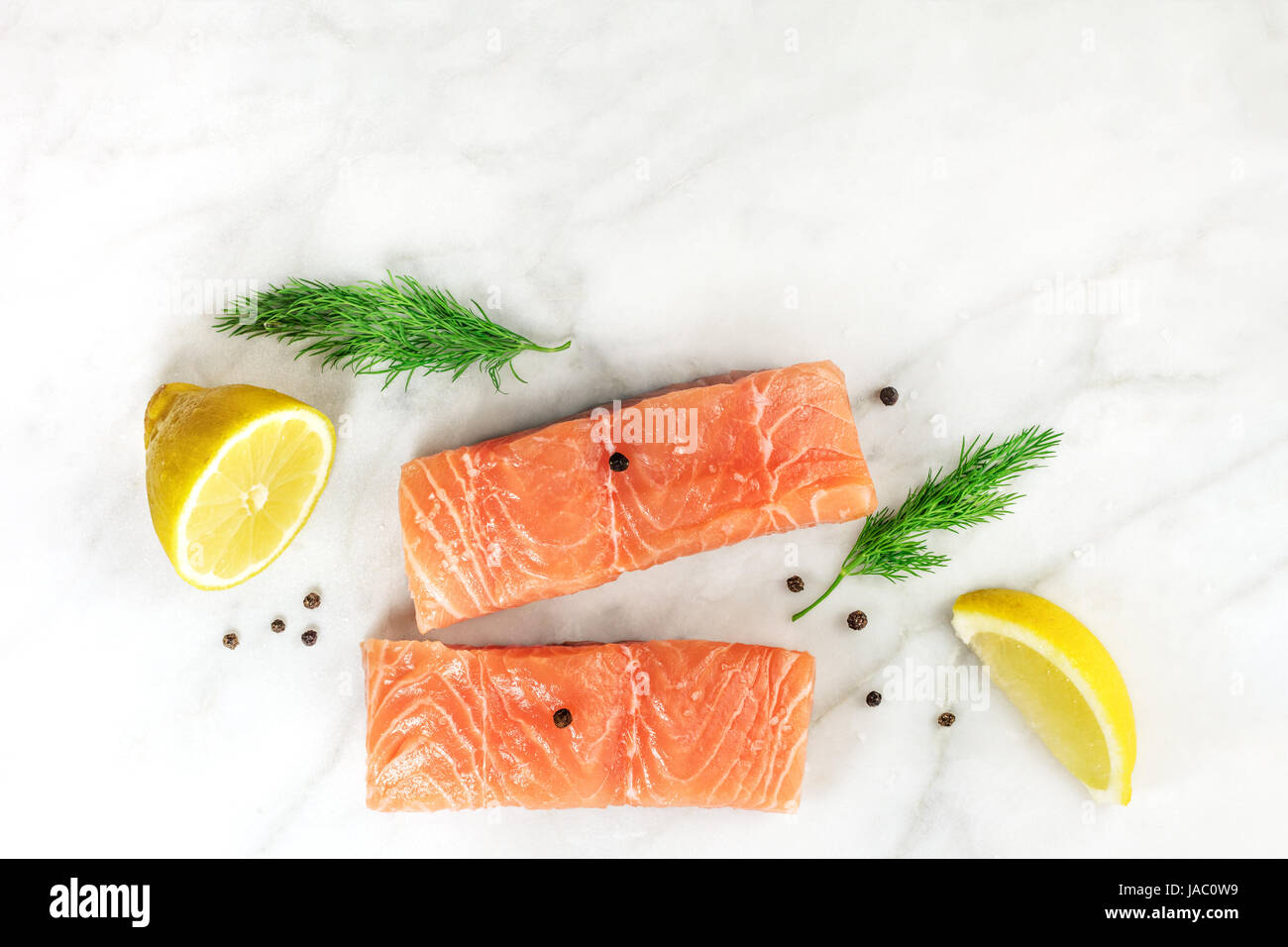 Fette di Salmone su bianco con i limoni, aneto e copyspace Foto Stock