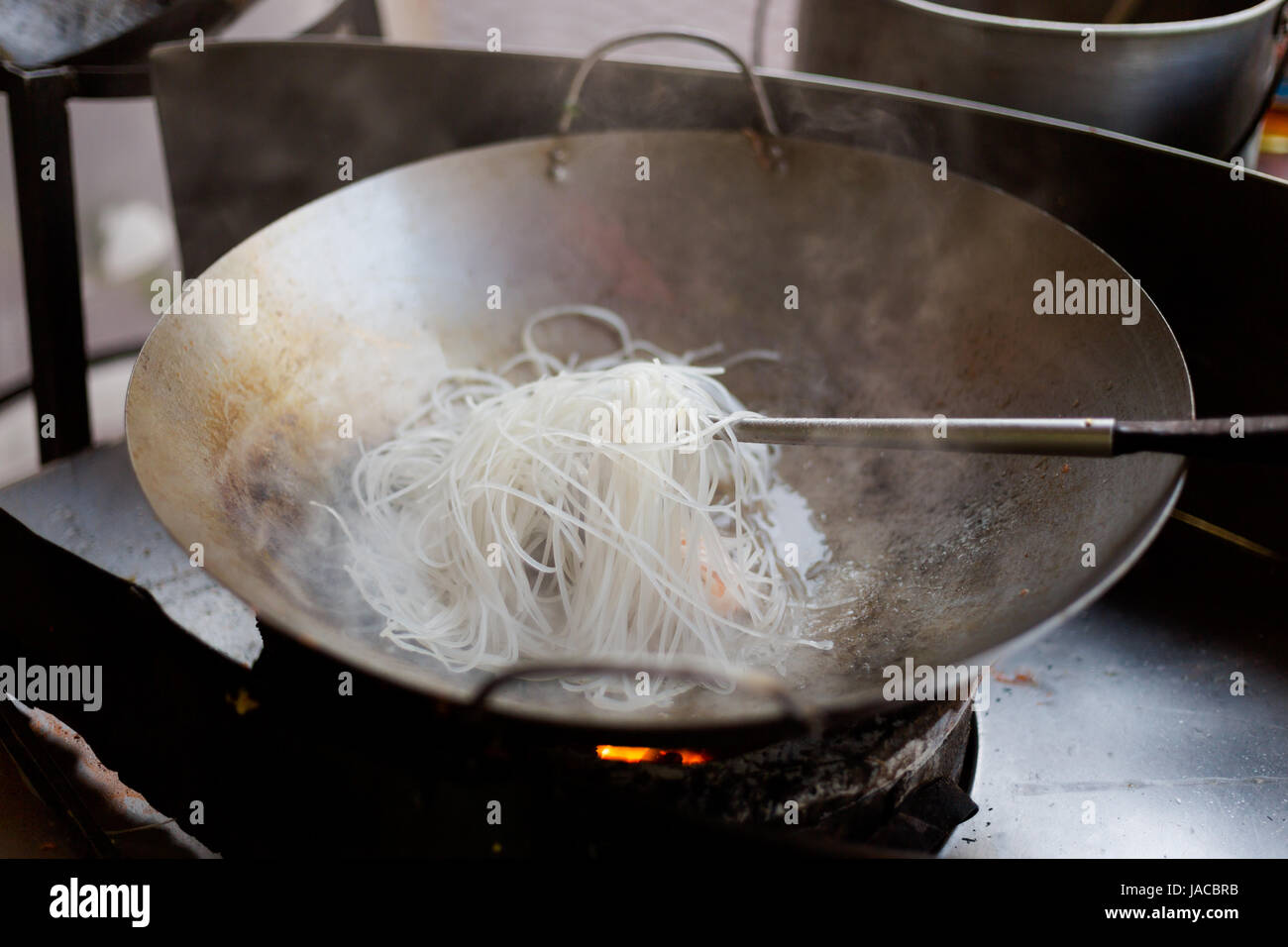 Vetro fritto a base di noodle con i germogli di soia, l'uovo e gamberetti. Il modo tradizionale di cucinare pad thai su wok padella. Foto Stock