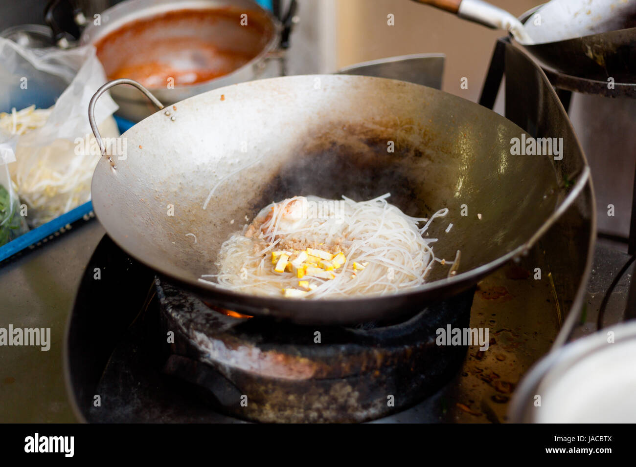 Vetro fritto a base di noodle con i germogli di soia, l'uovo e gamberetti. Il modo tradizionale di cucinare pad thai su wok padella. Foto Stock