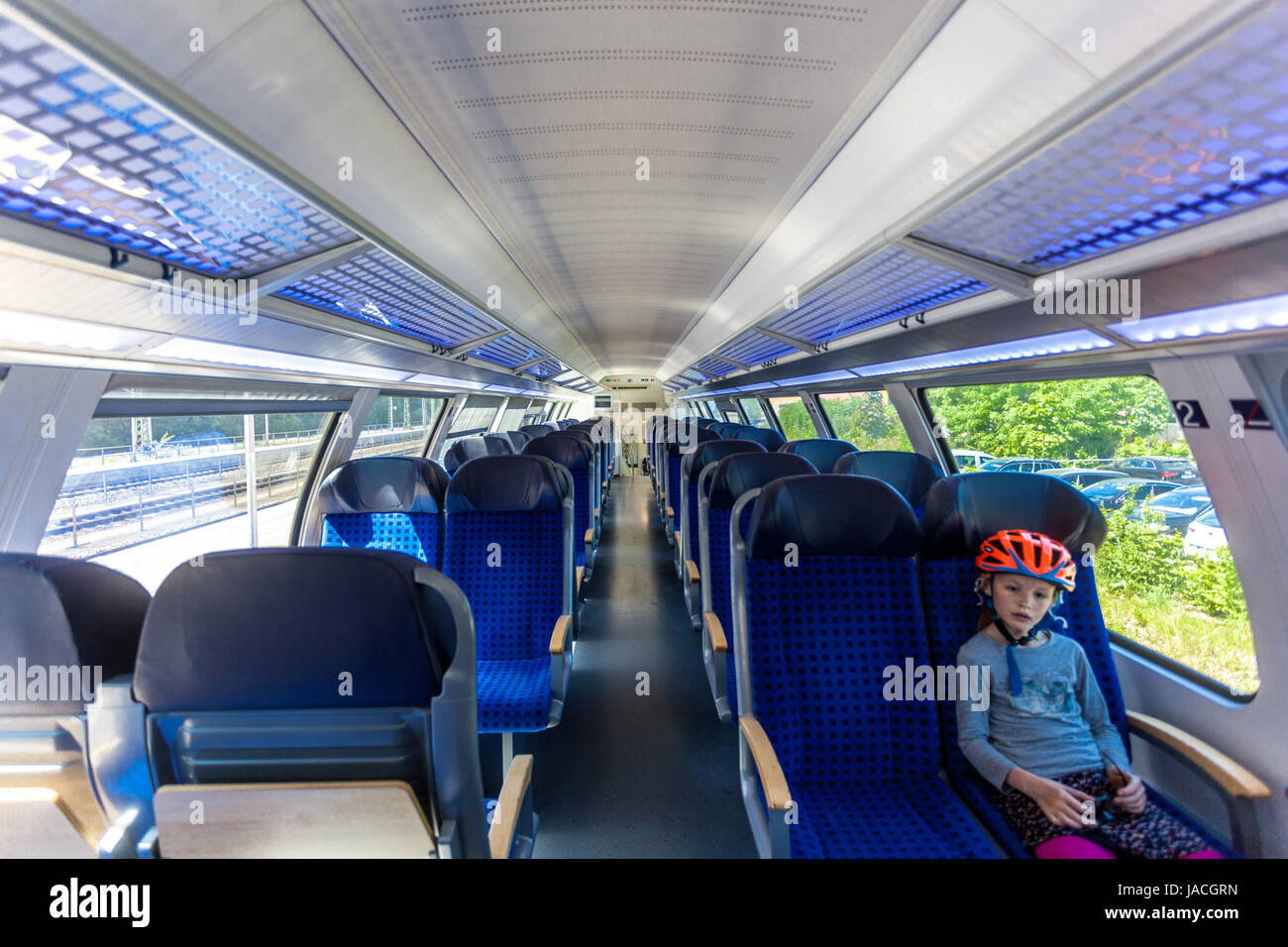Treno regionale Deutsche Bahn Girl all'interno del Wagon Germania treno Europa treno passeggeri tedesco bambino da solo in casco da bici treno interno pendolare Foto Stock