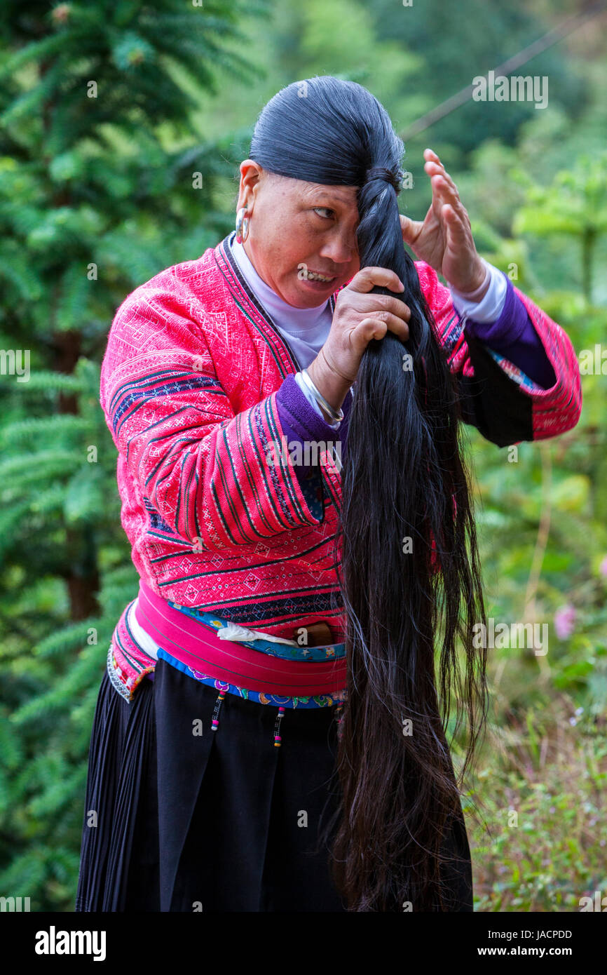 Longji, Cina. Donna di Yao minoranza etnica che mostra i suoi capelli lunghi. Foto Stock