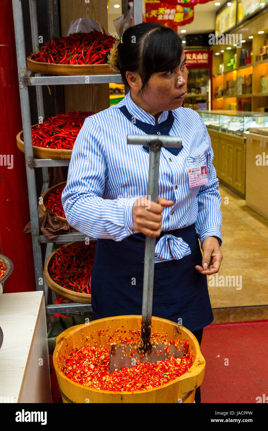 Yangshuo, Cina. Tritare il peperoncino in preparazione per la vendita. Foto Stock