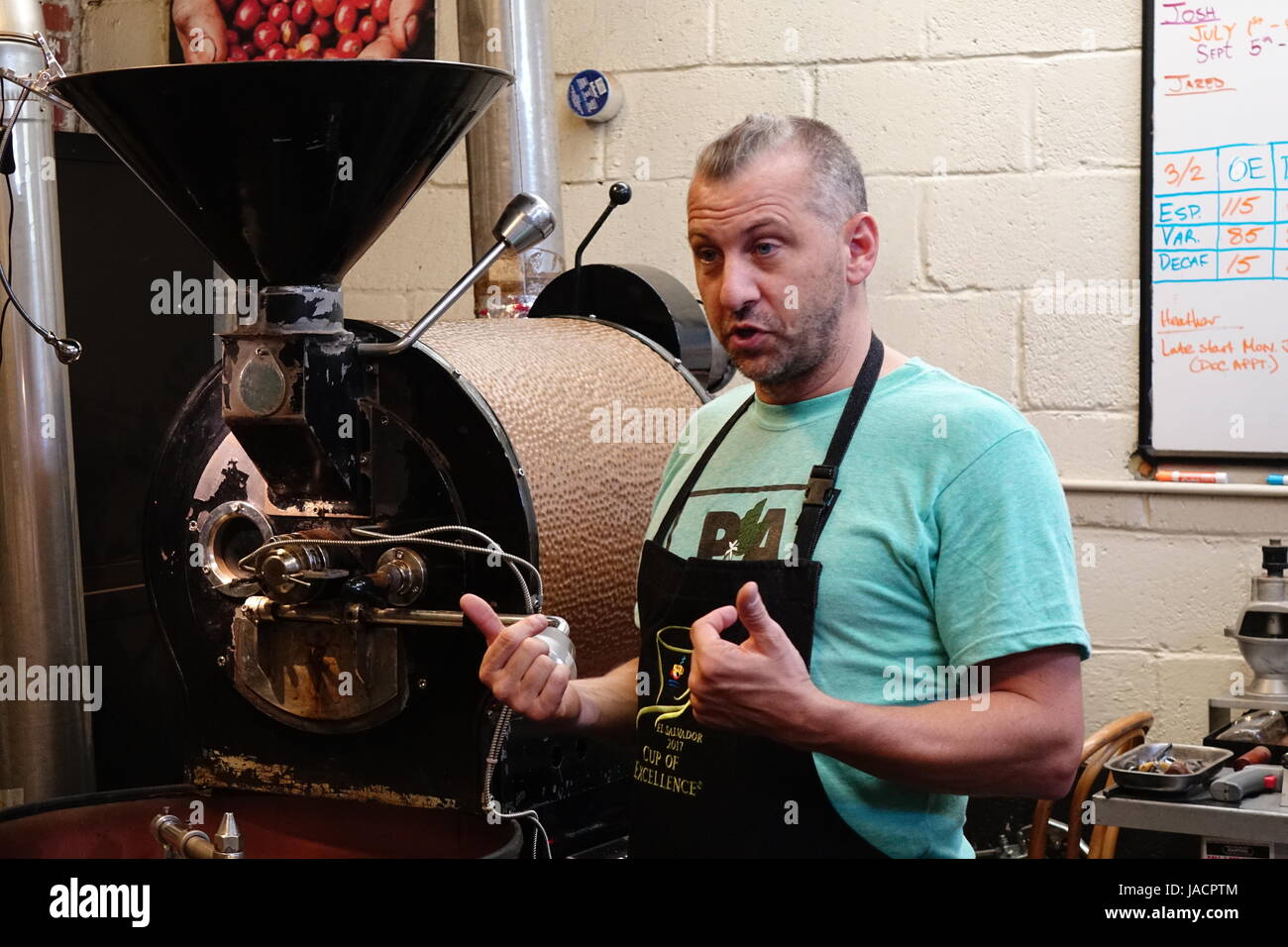 Scott Cornary, proprietario del caffè Carrboro turni di servizio e l'occhio aperto Café, descrive il processo di torrefazione di caffè Foto Stock