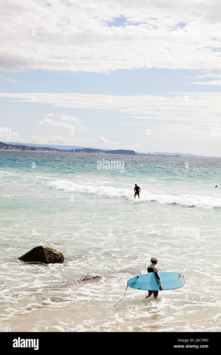 Un surfista entra nella spiaggia di Coolangatta sulla Gold Coast australiana Foto Stock