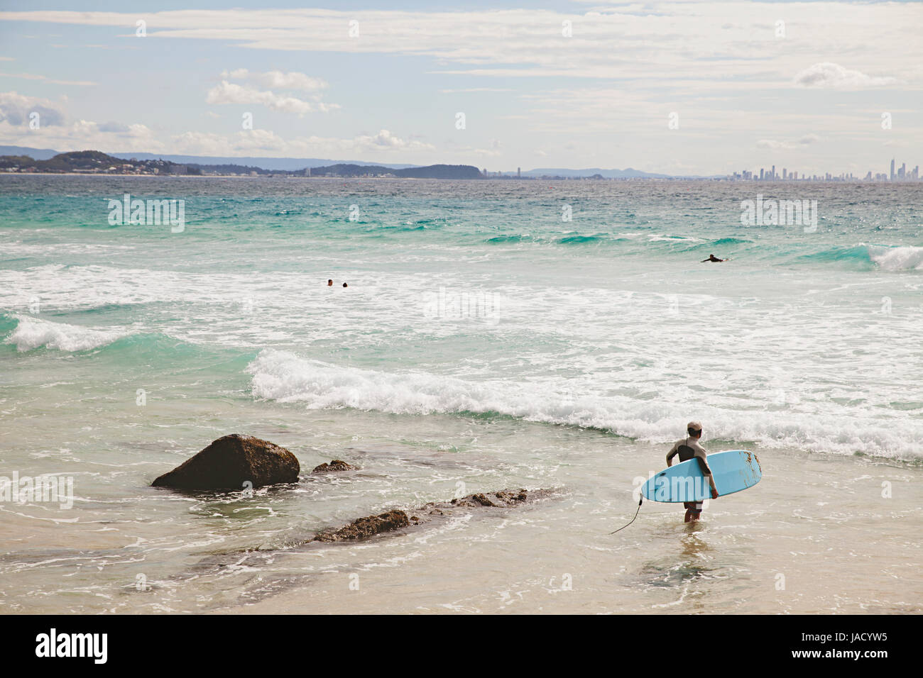 Un surfista entra nella spiaggia di Coolangatta sulla Gold Coast australiana Foto Stock