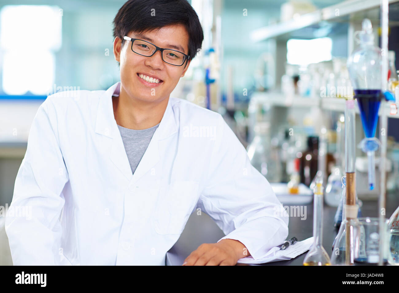 Un maschio laboratorio cinese scienziato che lavora presso il laboratorio con le provette per la prova Foto Stock