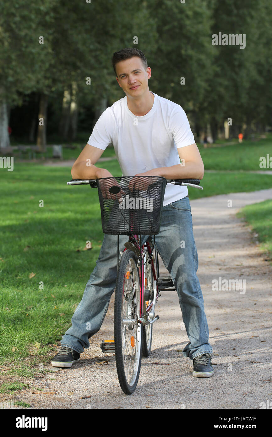 Ein junger Mann auf einem Fahrrad in einem Park Foto Stock