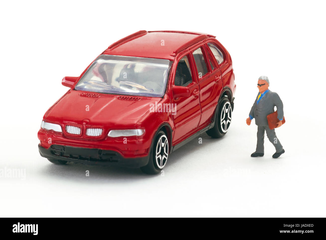Miniaturfigur mit Auto auf hellem Hintergrund Foto Stock