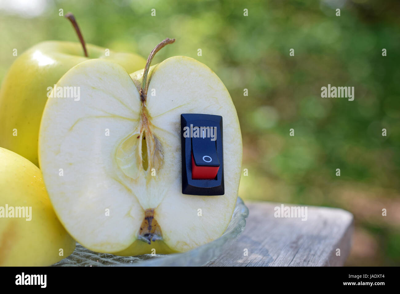 Le mele. Una mezza mela con inserito un interruttore di alimentazione. Cibo sano concetto con spazio per il testo. Foto Stock