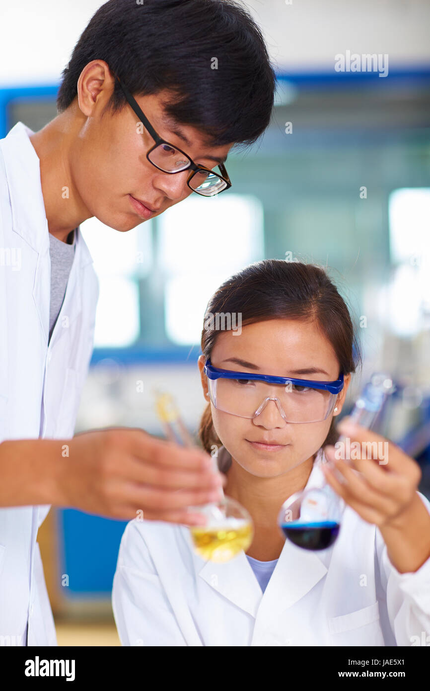 Due laboratori cinesi scienziato che lavora presso il laboratorio con le provette per la prova Foto Stock