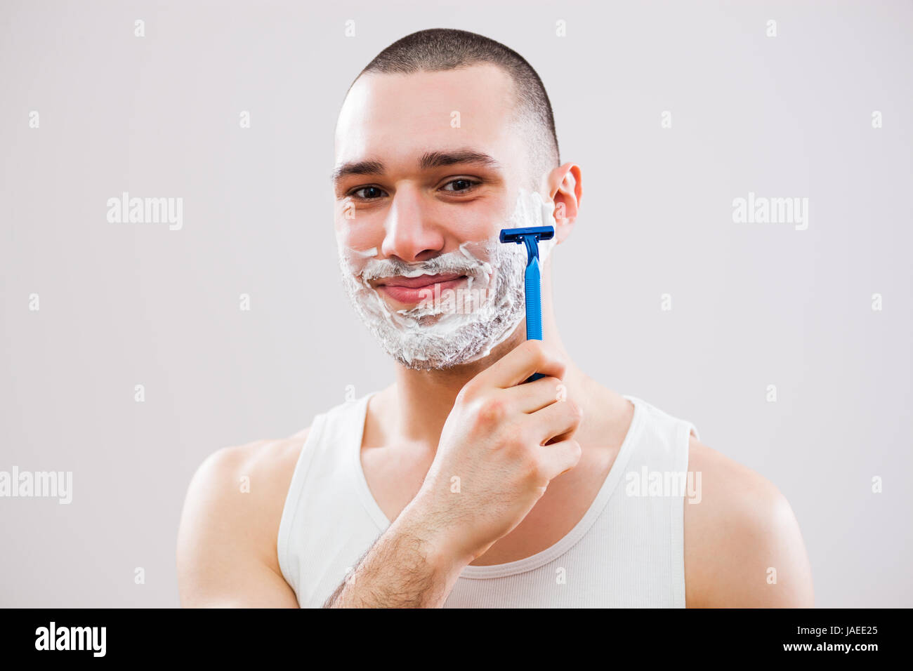 Giovane uomo è la rasatura la sua barba. Foto Stock
