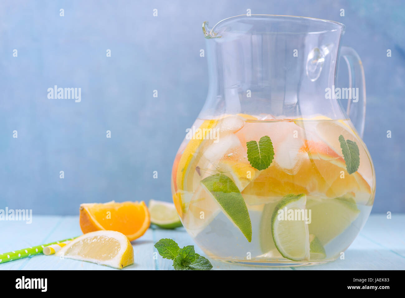La limonata brocca con limone, arancio, fettine di lime Foto Stock