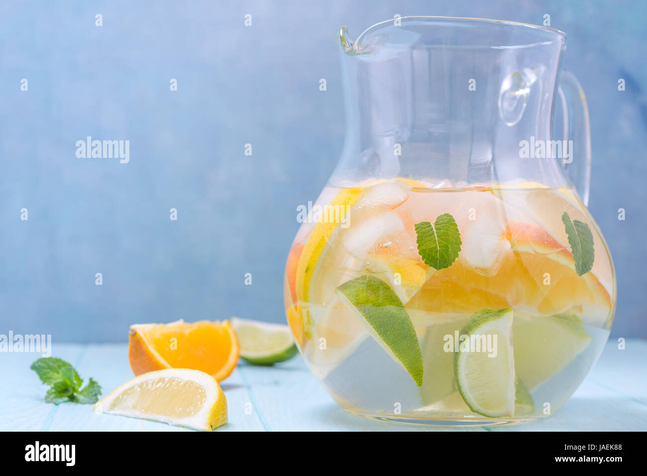La limonata brocca con limone, arancio, fettine di lime Foto Stock