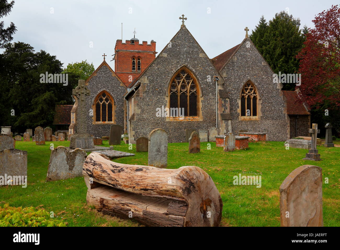 La bella chiesa locale nel tranquillo villaggio di Hurst vicino a Twyford con il suo vecchio albero panca ed erba rasata tutti molto ordinatamente kempt. Foto Stock