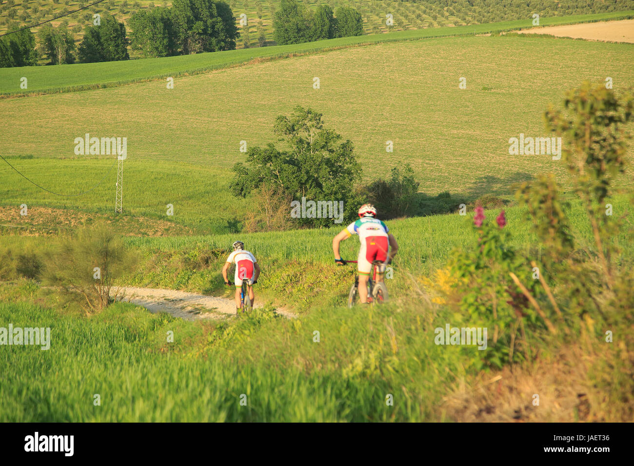 Due persone in bicicletta attraverso il Rio a Setenil valley, Cuevas del Marques, Serrania de Ronda, Spagna Foto Stock