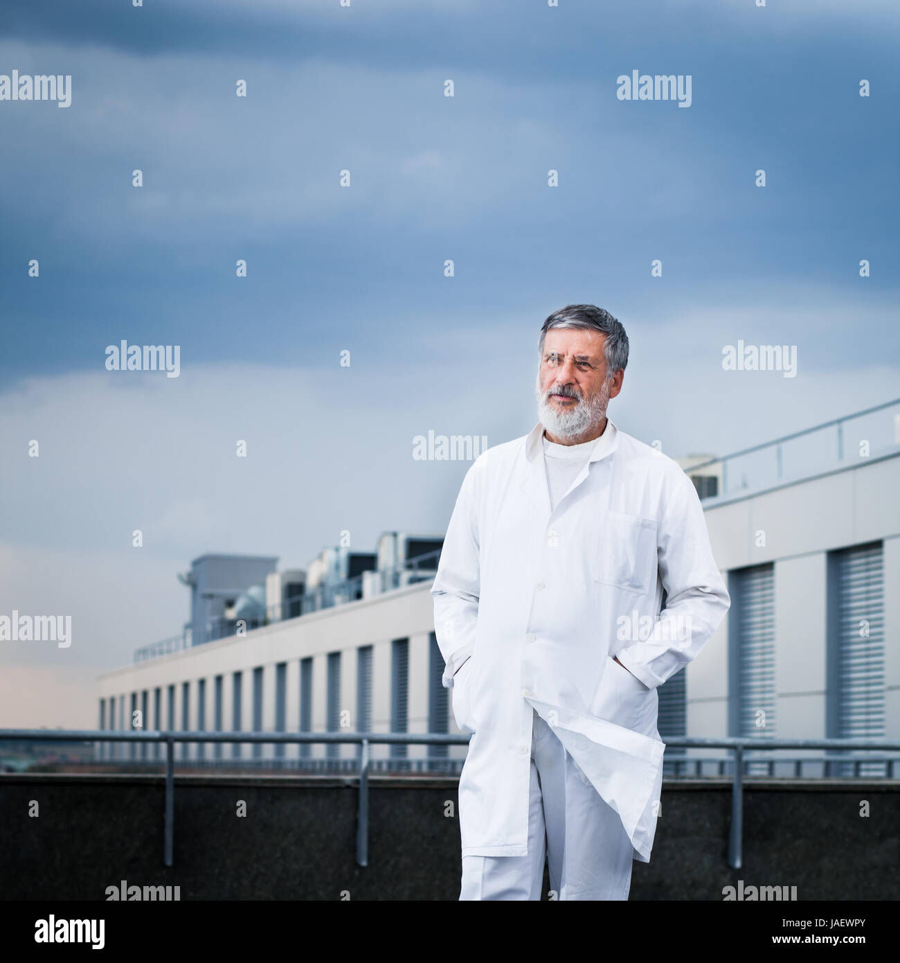 Scienziato di fama/medico in piedi sul tetto del centro di ricerca/hospital guardando fiduciosi (toni di colore immagine) Foto Stock