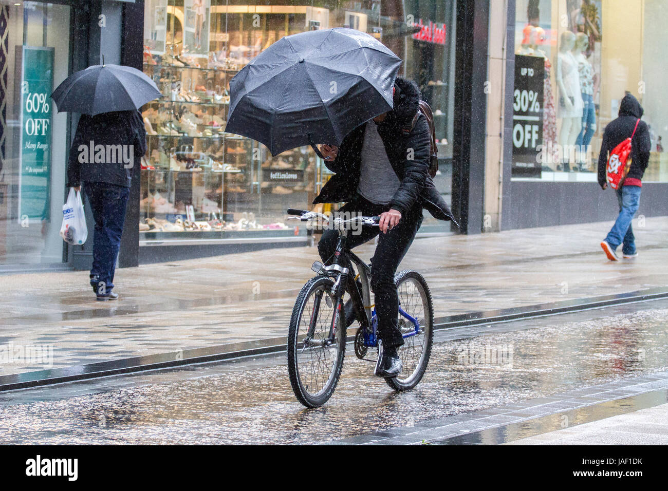 Un ciclista pioggia pioggia meteo inverno invernale colata di immergere imbevuto REGNO UNITO Inghilterra inglese britannico Ombrello Ombrelloni freddo umido persona docce raindrop umido Foto Stock