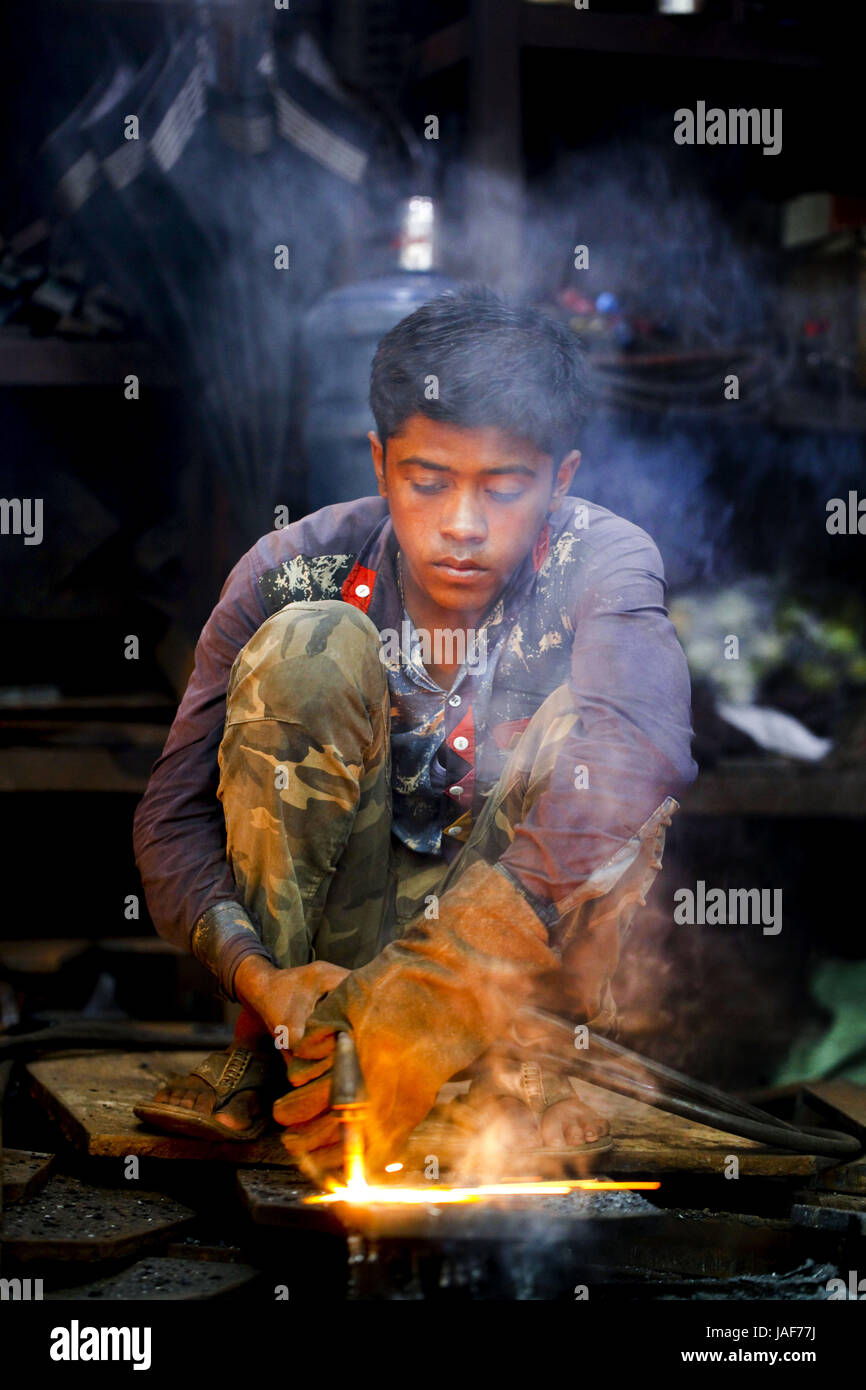 Dacca, Dhaka, Bangladesh. 5 Giugno, 2017. Giugno 05, 2017 Dacca in Bangladesh - Joshim (16) il taglio di un foglio di acciaio mediante il cilindro del gas alla banchina di fabbrica di metallo a Dhaka. Questo i lavoratori lavorano in un ambiente di lavoro limitato in spesso in condizioni di sovraffollamento e senza molto nel modo di apparecchiature di sicurezza. Lavorando in una fabbrica di metallo senza maschere o guanti appropriati li espongono al rischio di incidenti o problemi di salute. Credito: K M Asad/ZUMA filo/Alamy Live News Foto Stock