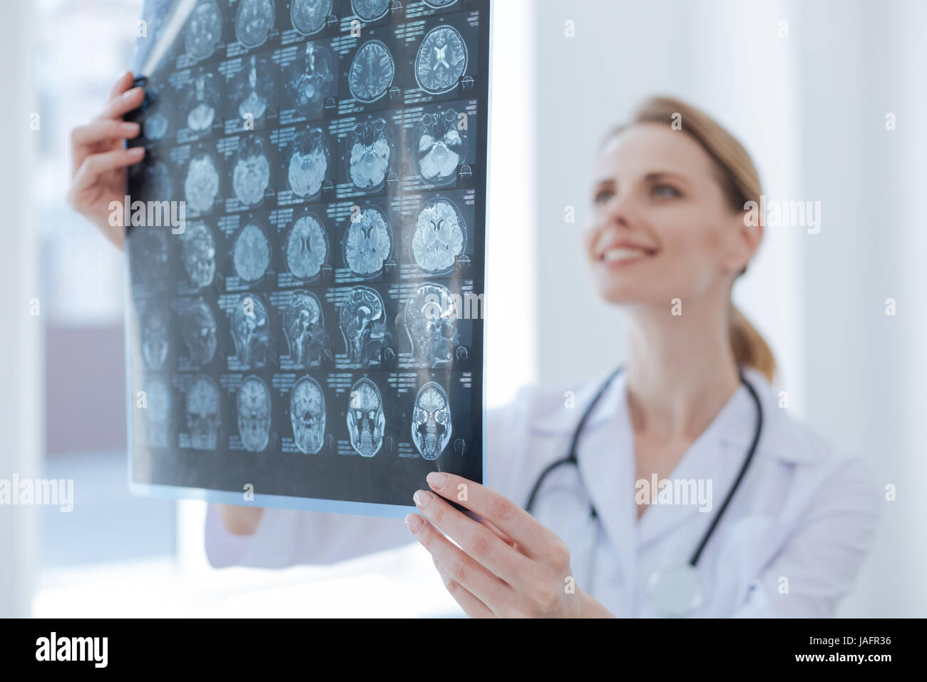 Fornire organismo qualificato l'esame. Qualificati lieto diligente radiologo lavorando presso la clinica durante l'esame ai raggi x per analizzare e diagnosticare il verdetto Foto Stock