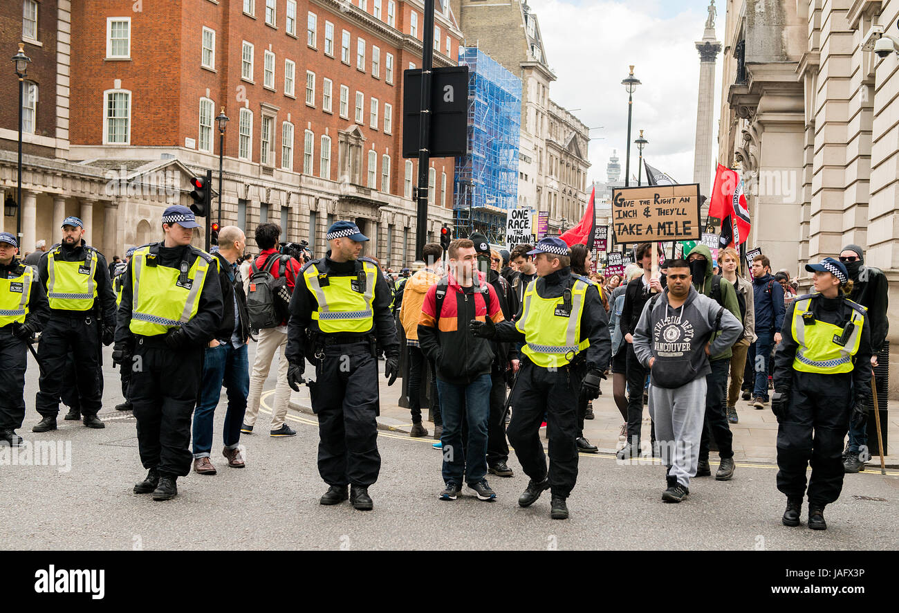 Gli ufficiali di polizia metropolitani scortano i sostenitori del movimento Unite Contro il fascismo che stanno dimostrando contro un rally EDL nel centro di Londra, nel Regno Unito. Foto Stock