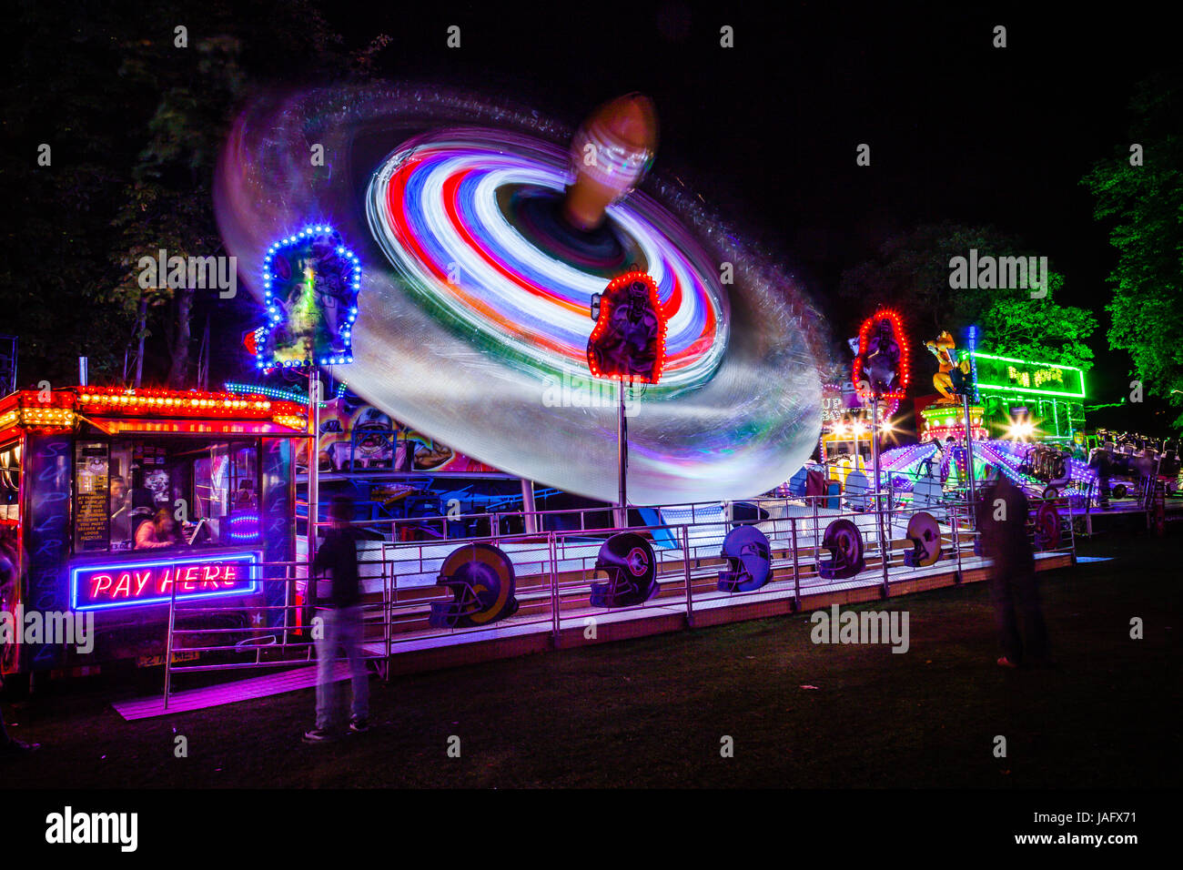 Traccia di luce da 'il Superbowl' fairground ride a Witney festa. Foto Stock