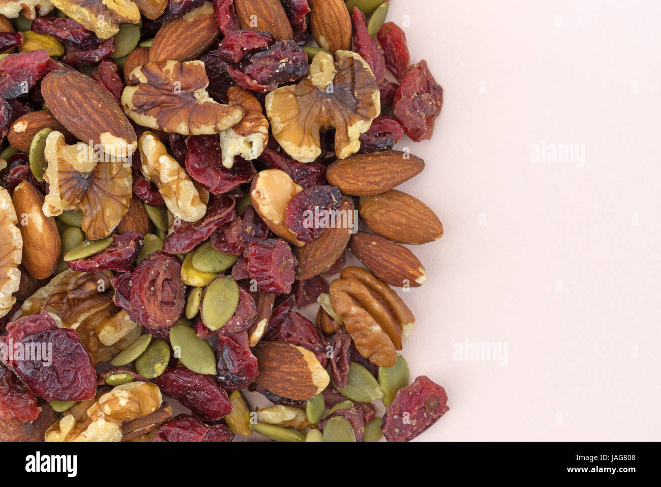Top vista ravvicinata di omega 3 percorso misto dadi e frutta su una rosa tagliere. Foto Stock