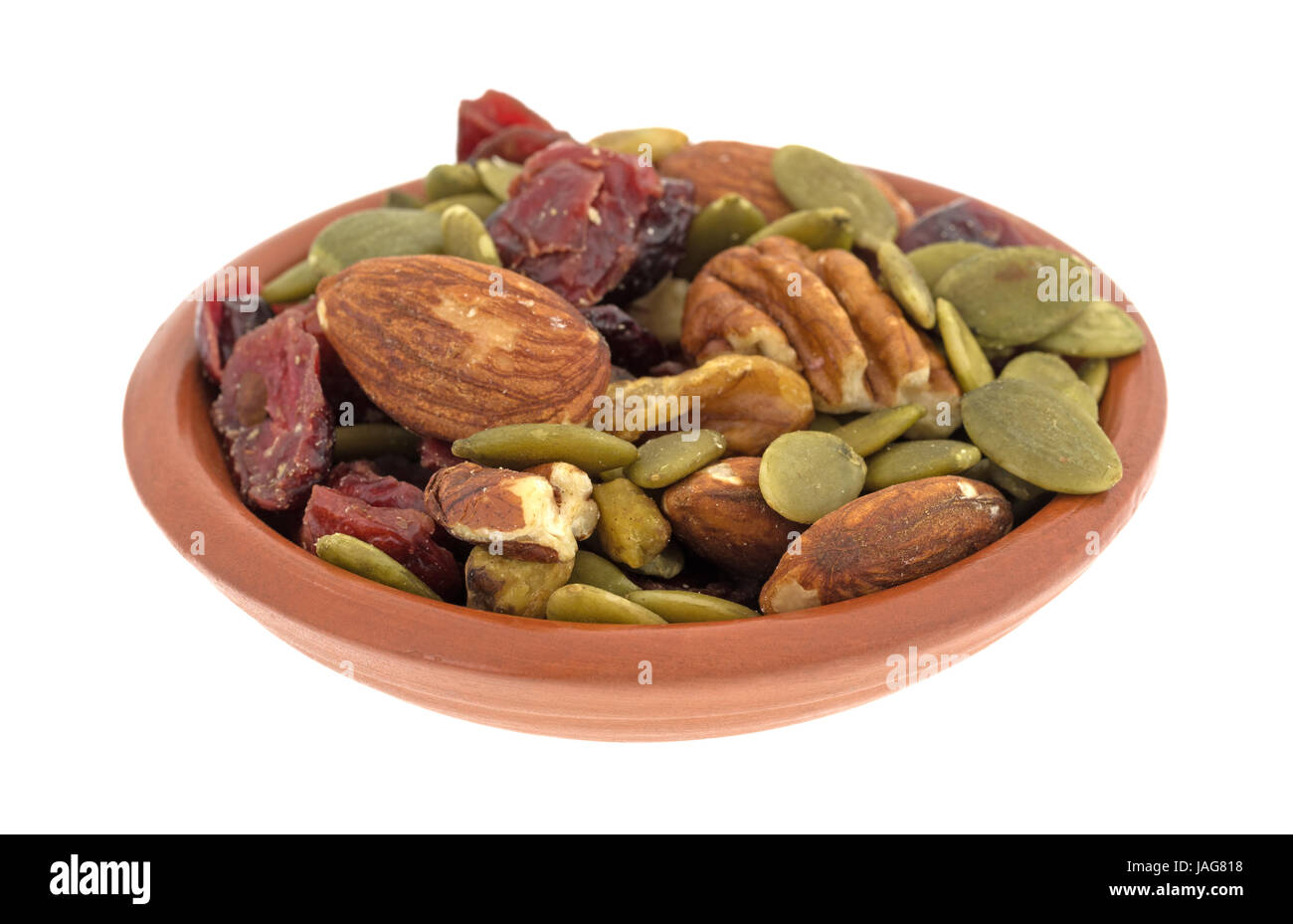 Omega 3 percorso misto dadi e ripieno di frutta di una piccola ciotola di argilla isolato su uno sfondo bianco. Foto Stock