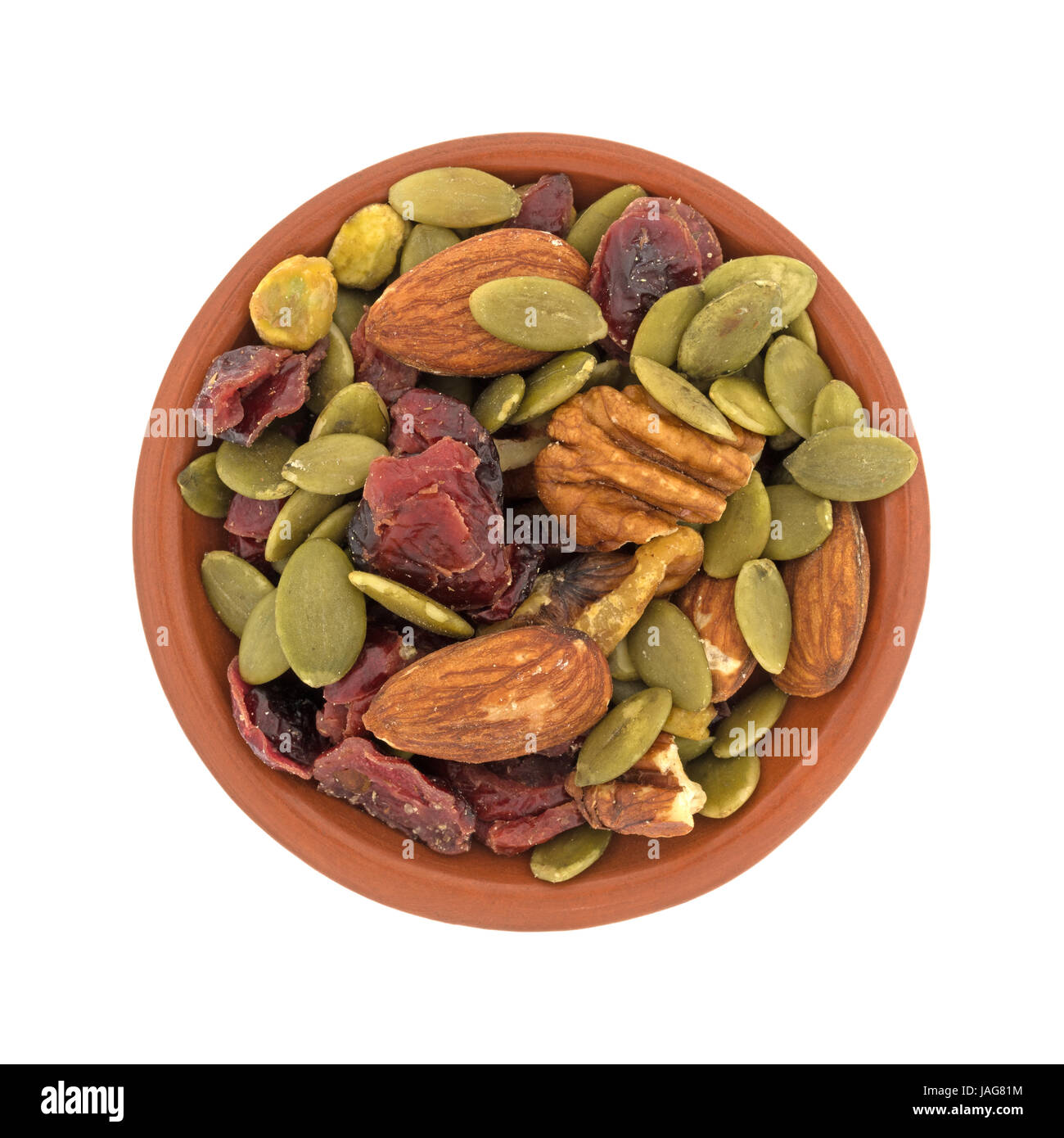 Vista superiore della omega 3 percorso misto dadi e frutta in una piccola ciotola di argilla isolato su uno sfondo bianco. Foto Stock