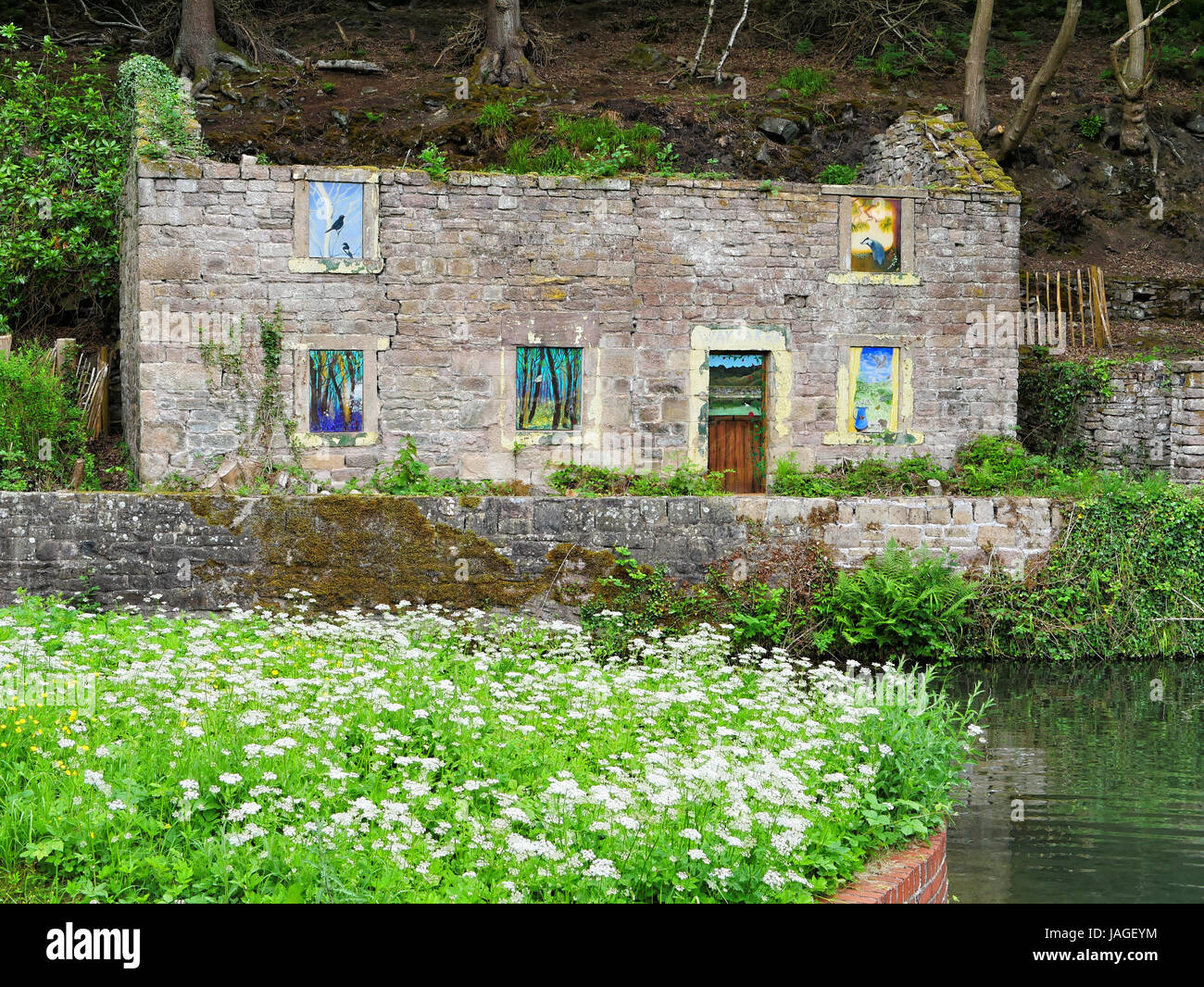 Edificio abbandonato sul canale di Cromford, Derbyshire, con finestre verniciate Foto Stock
