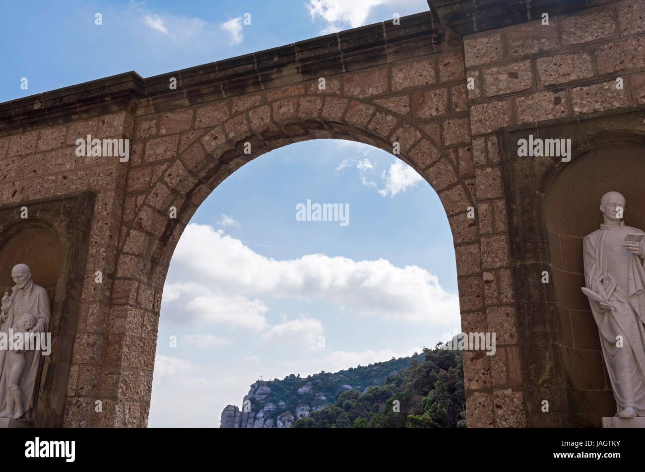 Vista delle montagne attraverso archway al di fuori di Santa Maria de Montserrat, Montserrat, Barcellona, Spagna Foto Stock