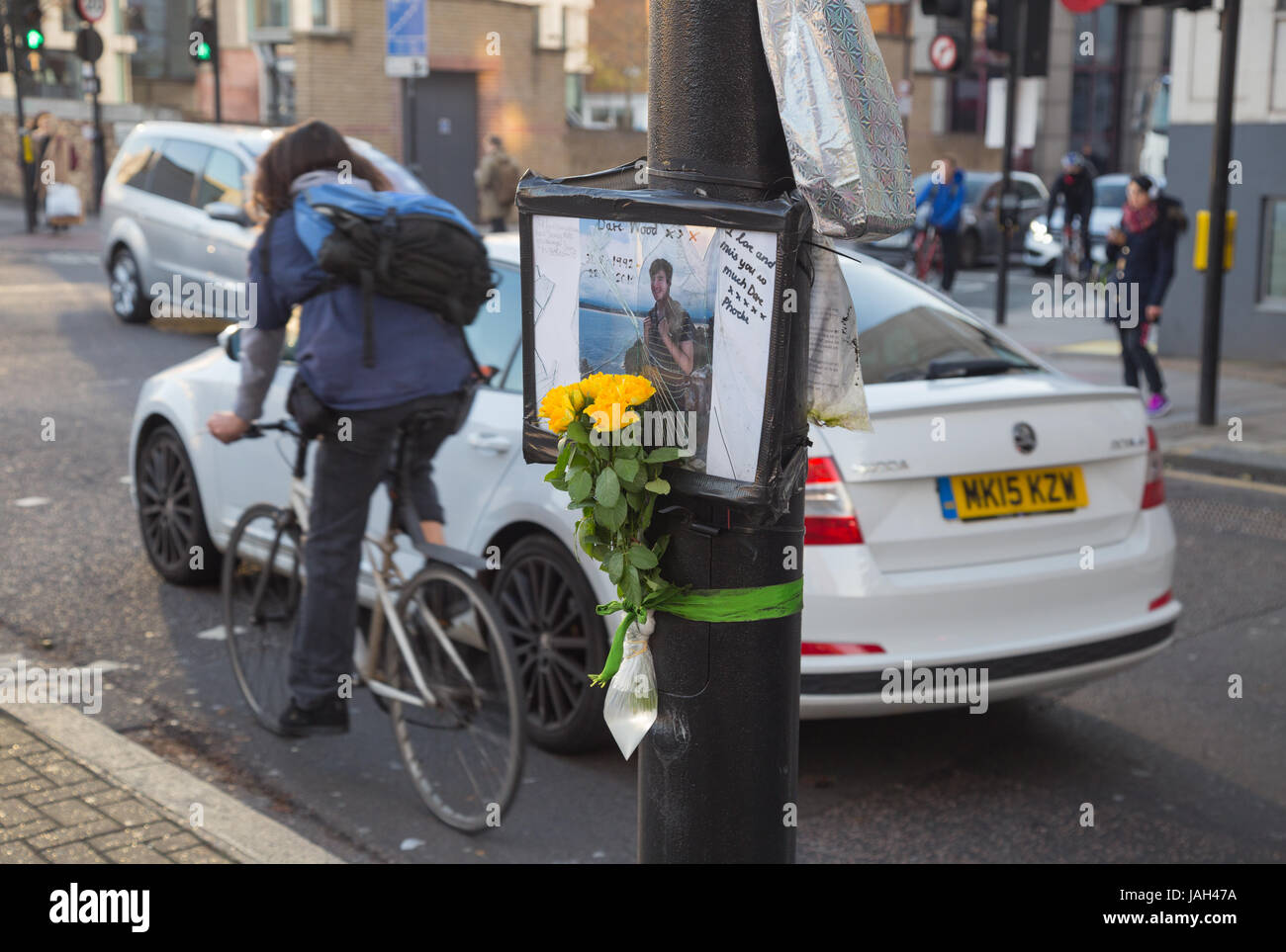 Auto e ciclista guidare oltre il memoriale di David Wood, pedonale ucciso da autobus in incidente stradale al bivio di Clerkenwell Rd e Farringdon Rd Londra EC1 Foto Stock