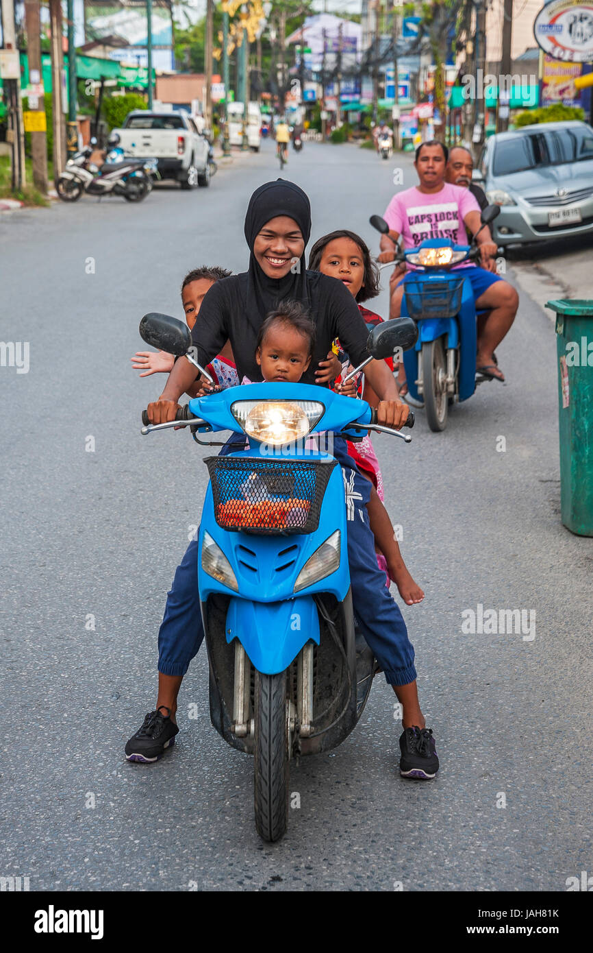 Madre con tre bambini su scooter, Chalong Bay, Phuket, Tailandia Foto Stock