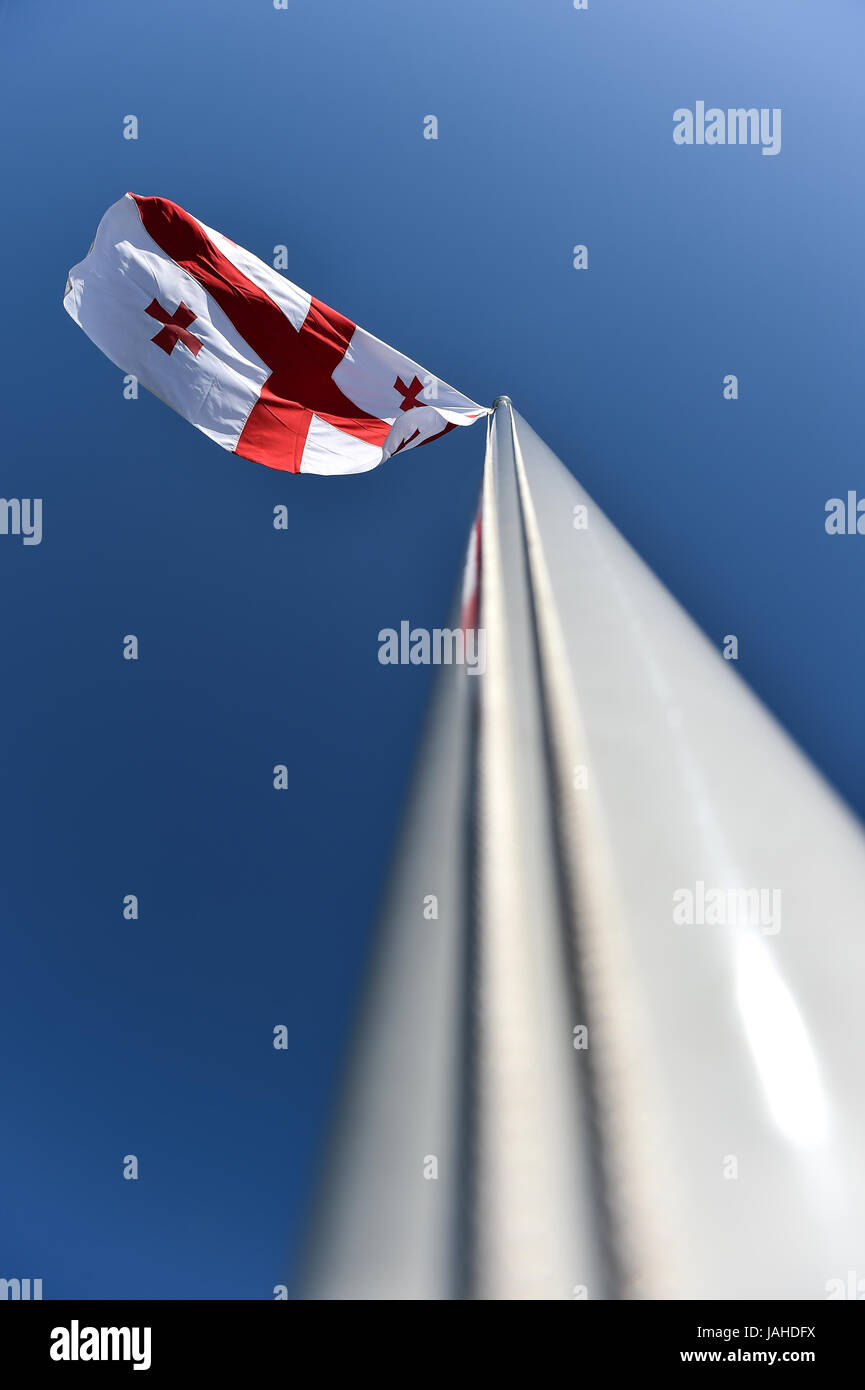 La Georgia bandiera nazionale soffiata dal vento contro un cielo blu Foto Stock