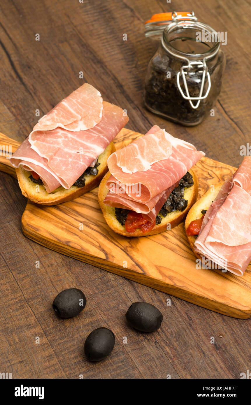 Snack mit Schinken rohen und Olivenpaste Hochformat im Foto Stock