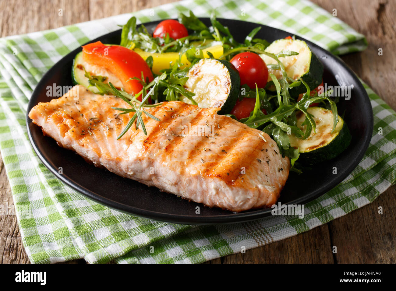 Filetto di salmone alla griglia con insalata di zucchine, rucola, pepe e  pomodori vicino sul tavolo orizzontale Foto stock - Alamy