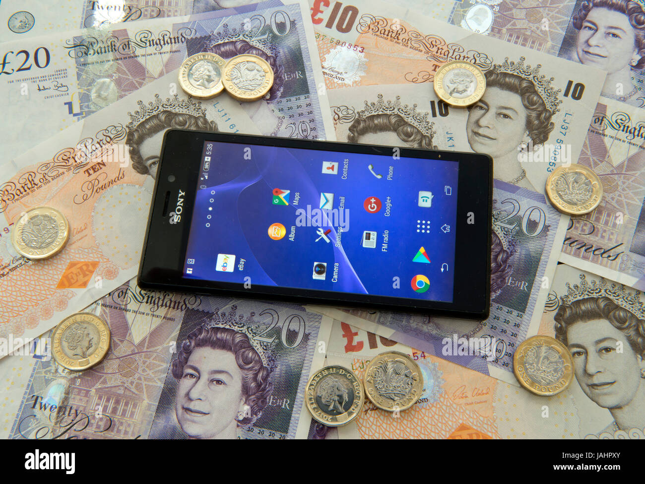 Un mobile (android) telefono su uno sfondo di valuta britannica Foto Stock