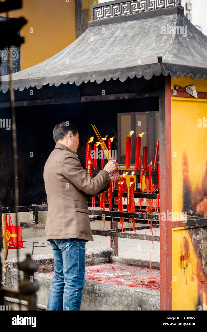 Adoratore luci e candele insence al tempio di mistero, un complesso taoista fondata nel Song Dynasty, Suzhou, provincia dello Jiangsu, Cina Foto Stock