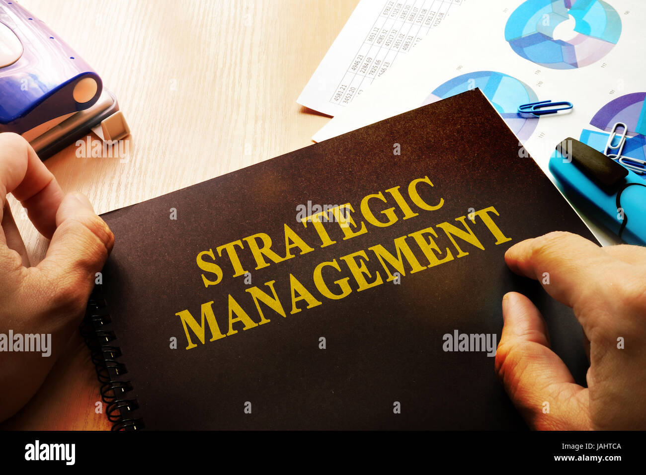 Mani che tengono i documenti con il titolo di gestione strategica. Foto Stock