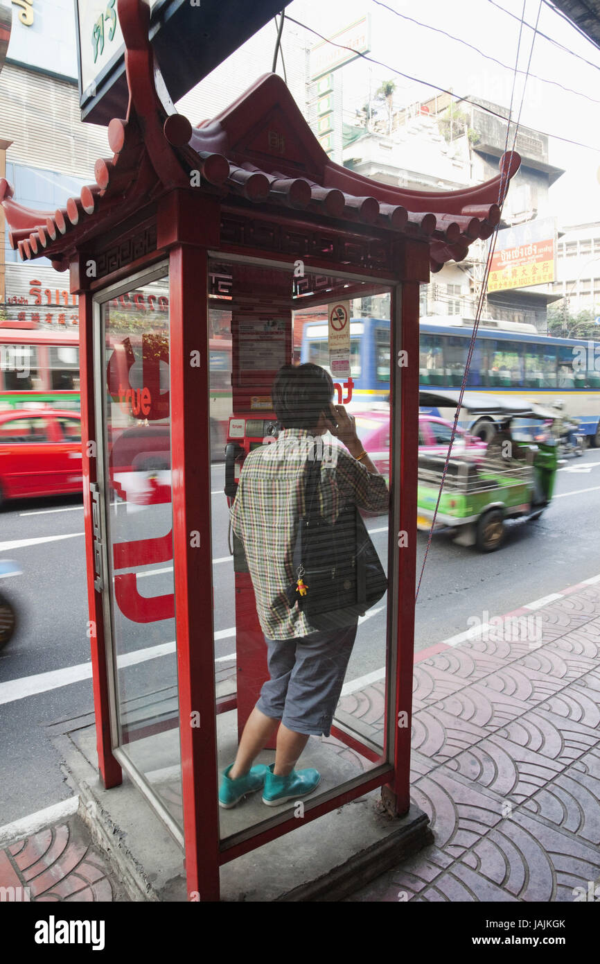 Per sfuggire alla Thailandia, Bangkok,Chinatown,l'uomo con il cellulare nel telefono casella intorno al rumore del traffico, Foto Stock