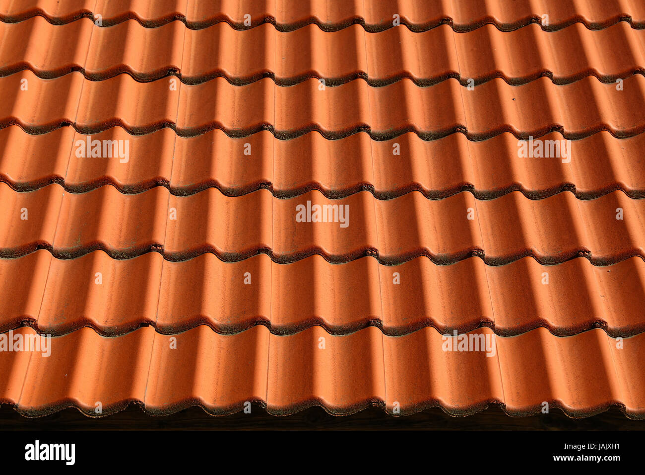 Tradizionale in rosso marrone ceramica tegole del tetto sfondo pattern, chiudere fino a basso angolo di vista laterale Foto Stock