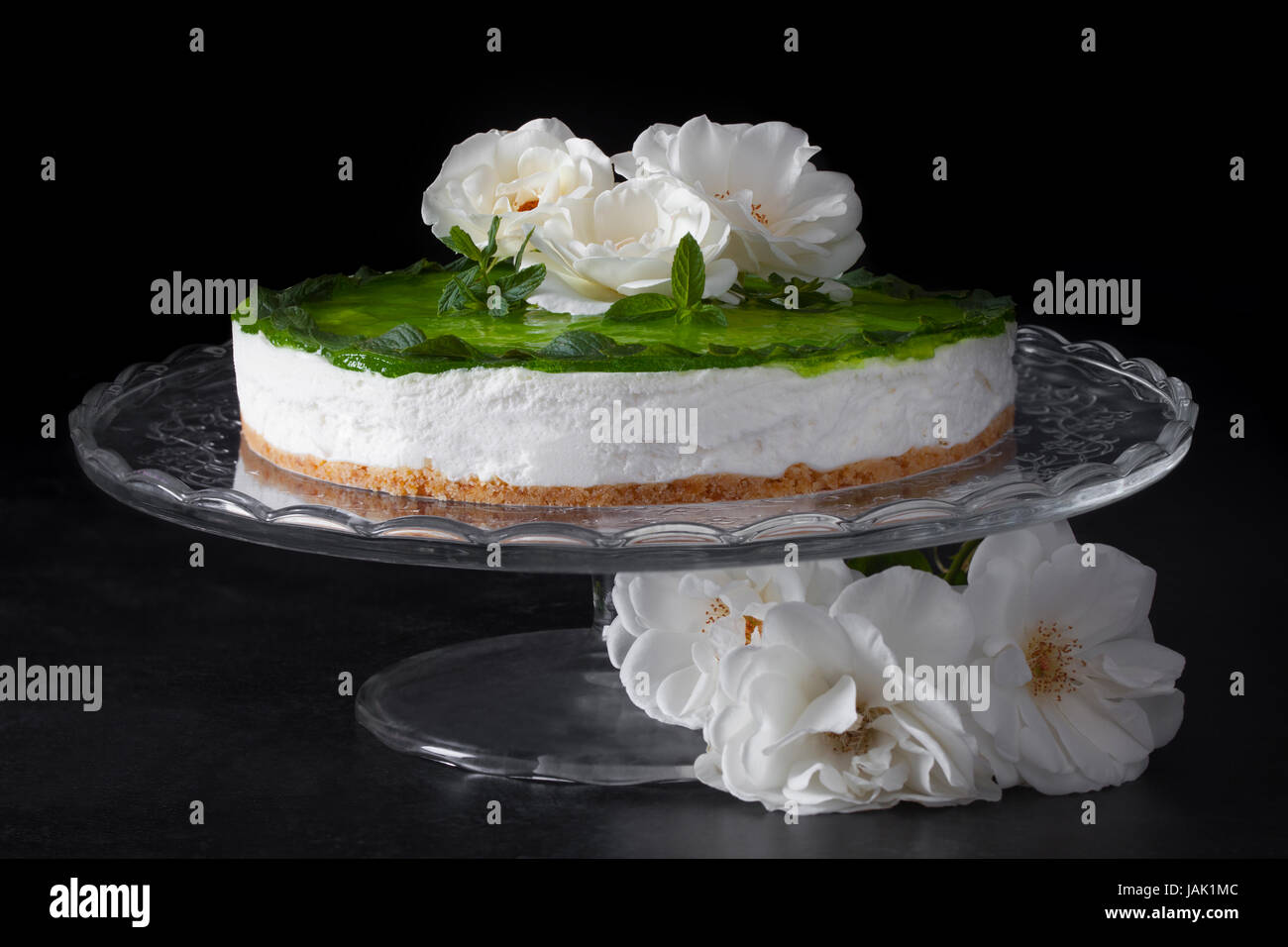Il Mojito la torta con la menta e rum decorate con rose, su sfondo nero. Foto Stock
