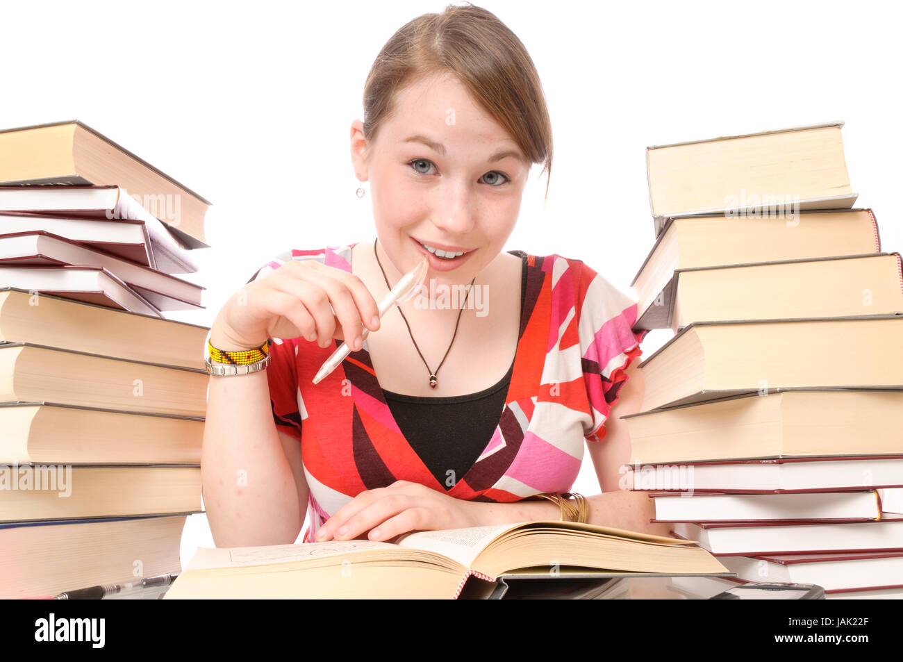 Mädchen, Schülerin beim Lernen, Hausaufgaben machen am Schreibtisch mit Büchern vor weißem Hintergrund. Foto Stock