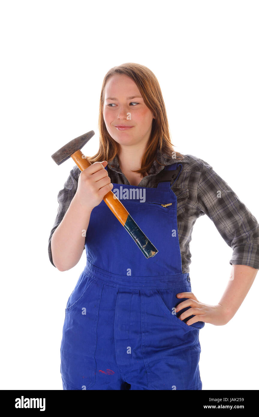 Junge Frau (Handwerkerin, Heimwerkerin, Auszubildende) mit langen Haaren trägt eine karierte Bluse und eine blaue Arbeits-Latzhose vor weißem Hintergrund. Hält Sie einen martello in der mano Foto Stock