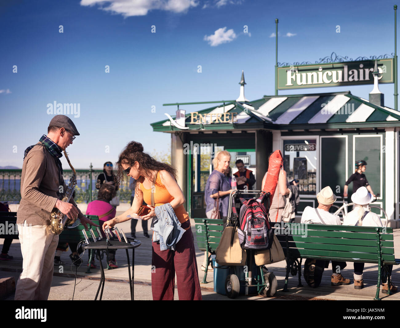 Licenza disponibile su MaximImages.com Woman Tourist che acquista un CD di un musicista di strada, un sassofonista, in funicolare nella vecchia Quebec City, Canada Foto Stock