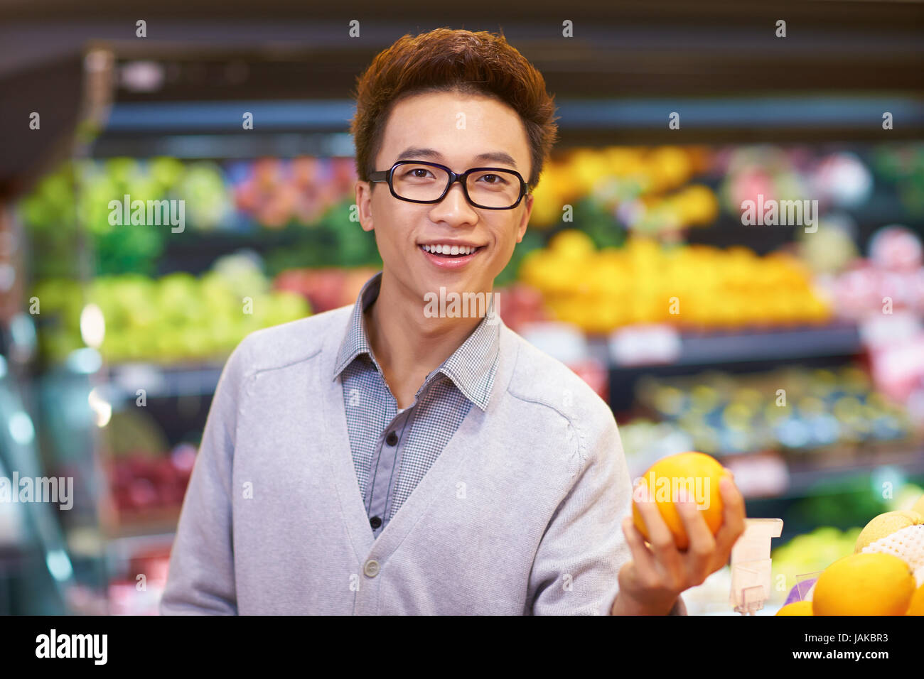 Un giovane uomo cinese acquisto di frutta fresca nel mercato Foto Stock Un giovane uomo cinese acquisto di frutta fresca nel mercato Foto Stock