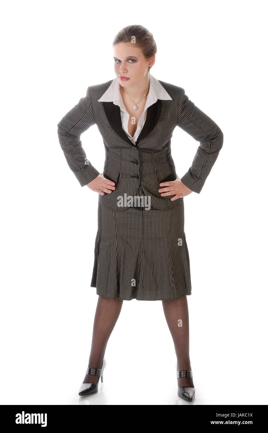 Junge Frau im grauen Business-Anzug und High-Heels posiert vor weißem Hintergrund Foto Stock