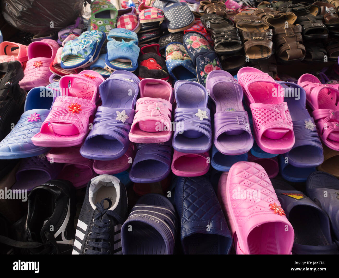 Il quotidiano mercato all'aperto in Şəki (trascritto Shaki o Sheki) nel nord Azerbaigian offre colorate ciabatte di plastica e sandali in rosa e viola Foto Stock