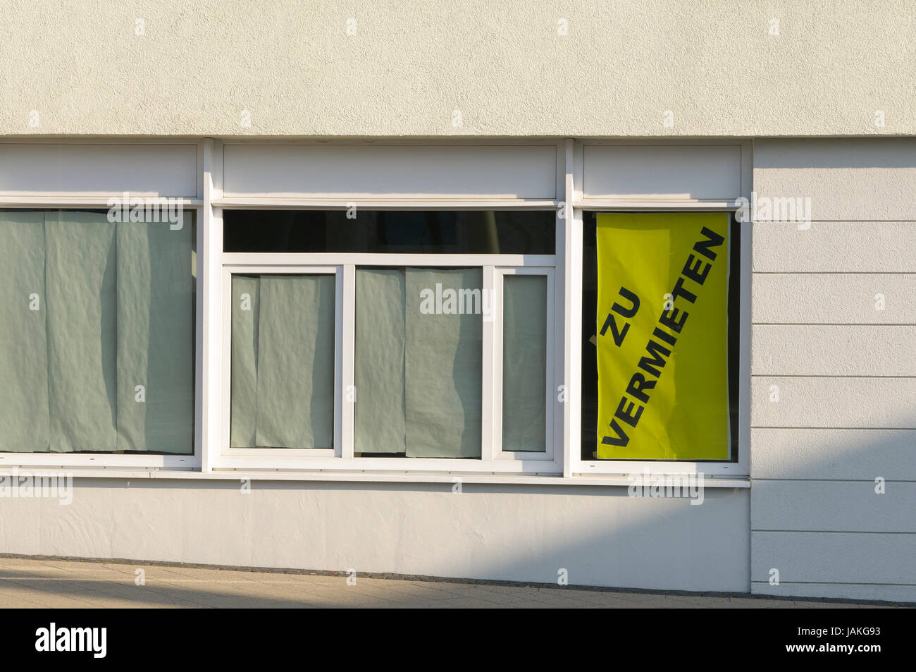 In einem urbanen Gebäude steht die untere Etage leer, es prangt ein großes 'zu vermieten' Schild im Fenster. Foto Stock