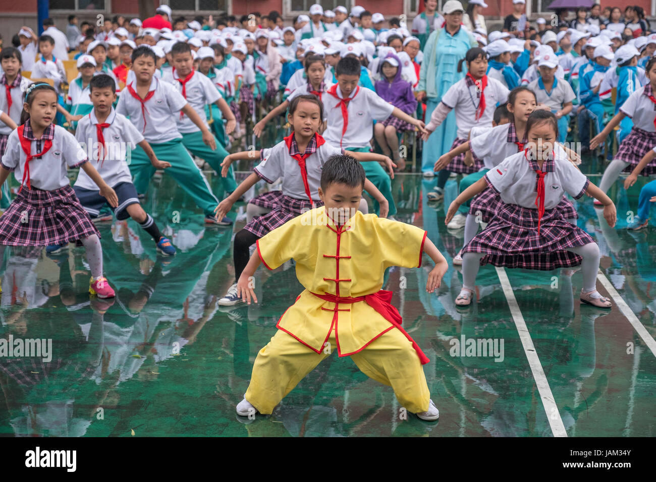 Gli alunni cinesi eseguire arte marziale o Wushu in una scuola primaria a Pechino in Cina. Foto Stock
